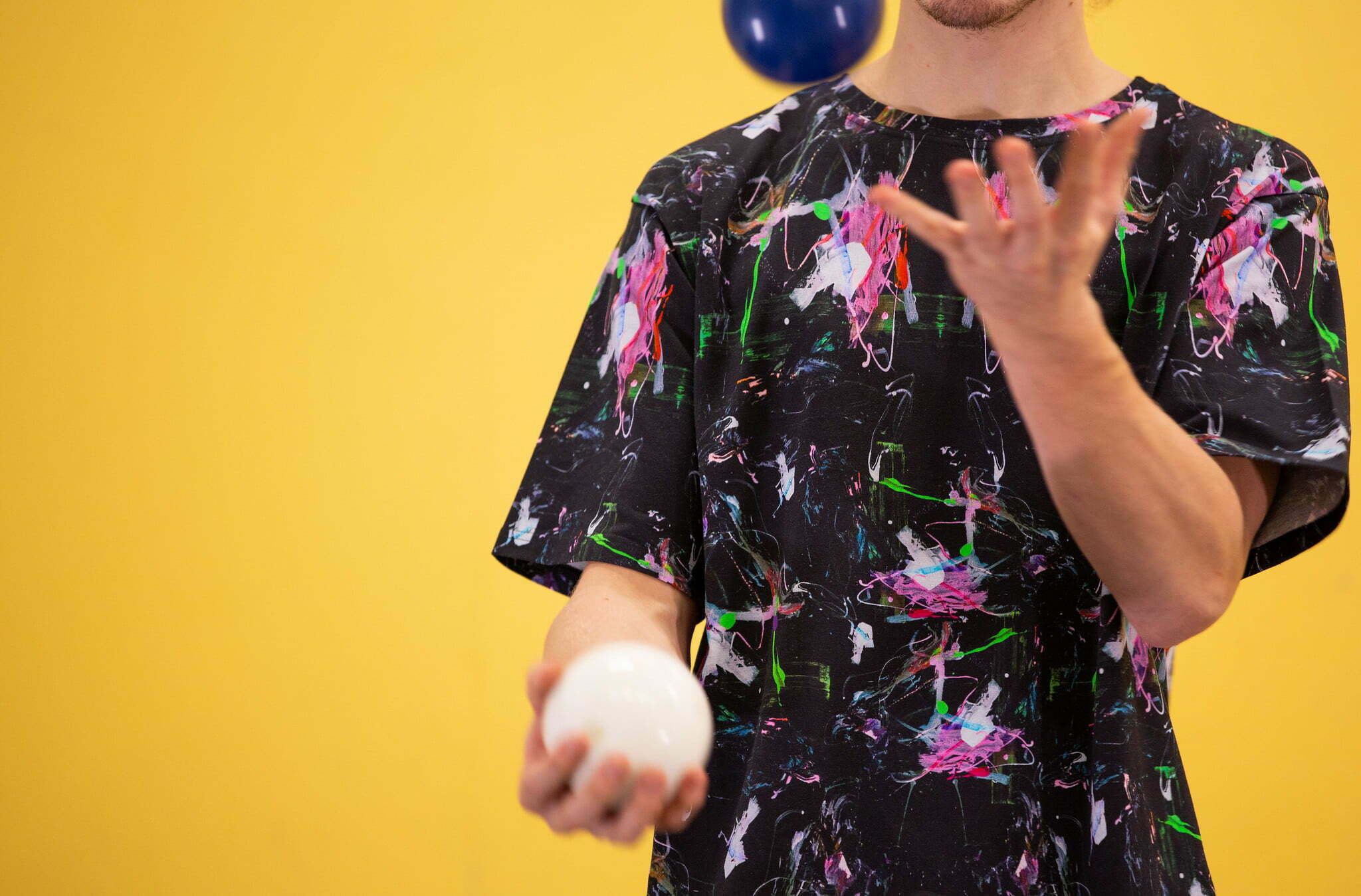 Kuvassa henkilö harjoittelee jongleerausta kahdella pallolla.