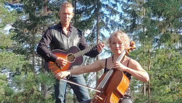 Duo Sävy kesäisessä metsämaisemassa soittamassa. Sellisti soittaa istuen, kitaristi säestää seisoma-asennossa.