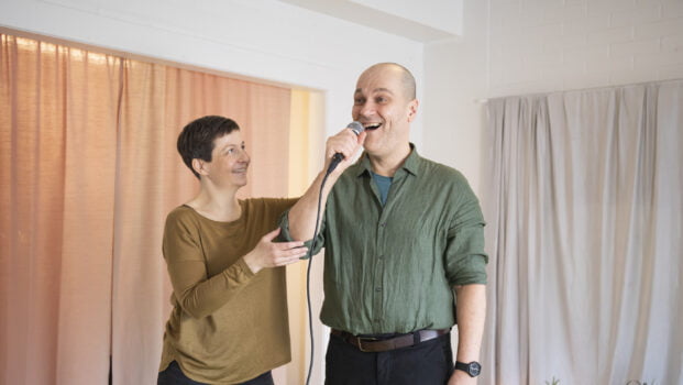 Katja Harilo ohjaa miestä joka laulaa mikrofoniin