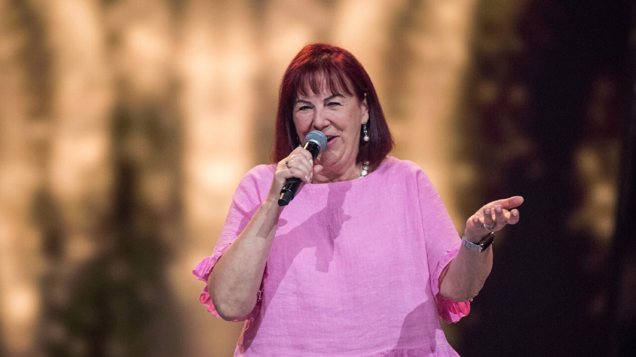 Ewa laulaa mikrofoniin pinkki asussa.