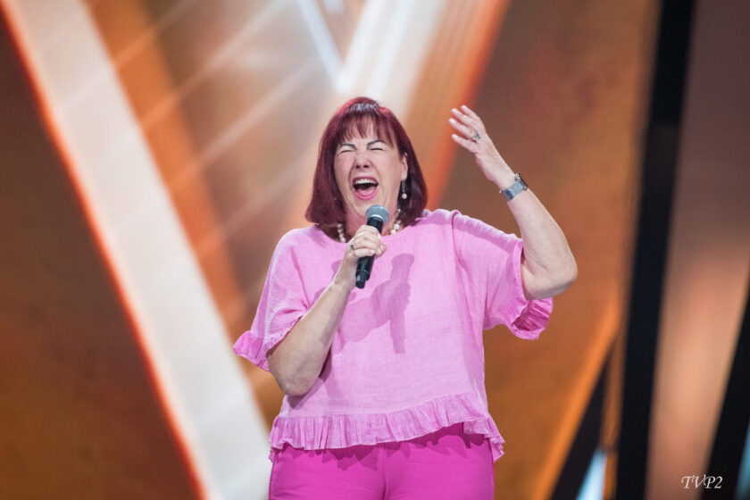 Ewa laulaa mikrofoniin pinkkiasussa.