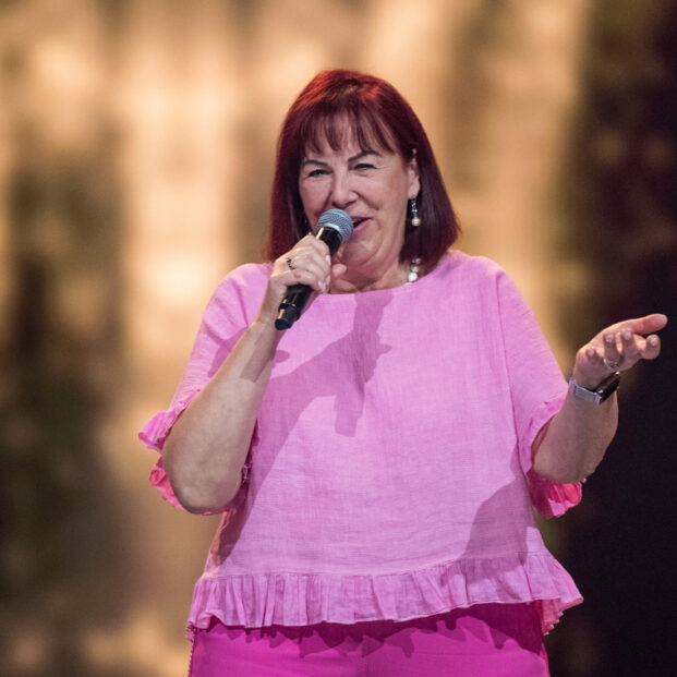 Ewa laulaa mikrofoniin pinkki asussa.