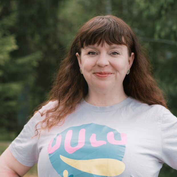 Kuvassa muusikko Petra Käppi seisoo metsäistä taustaa vasten ja katsoo suoraan kameraan hymyillen, kädet lanteillaan. Hänen t-paidassaan on tekstit "Uulu" ja "20 vuotta".