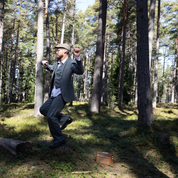 Mies tanssii metsässä.