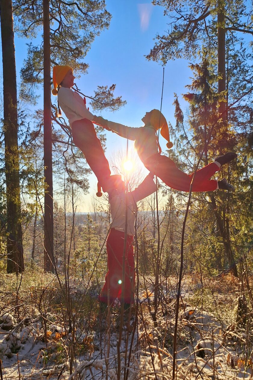 Kolme ihmistä tekee ihmispyramidia