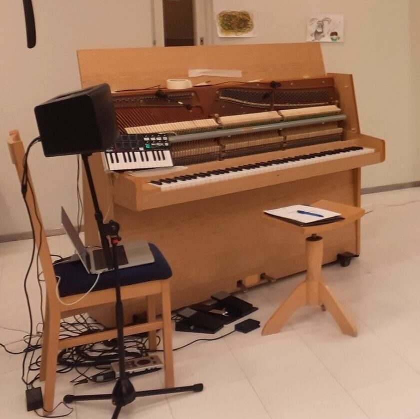 pystypiano ilman etulevyä sekä musiikkilaitteistoa