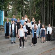 Ryhmäkuva Aukea Ensemblen laulajista ulkona portailla.